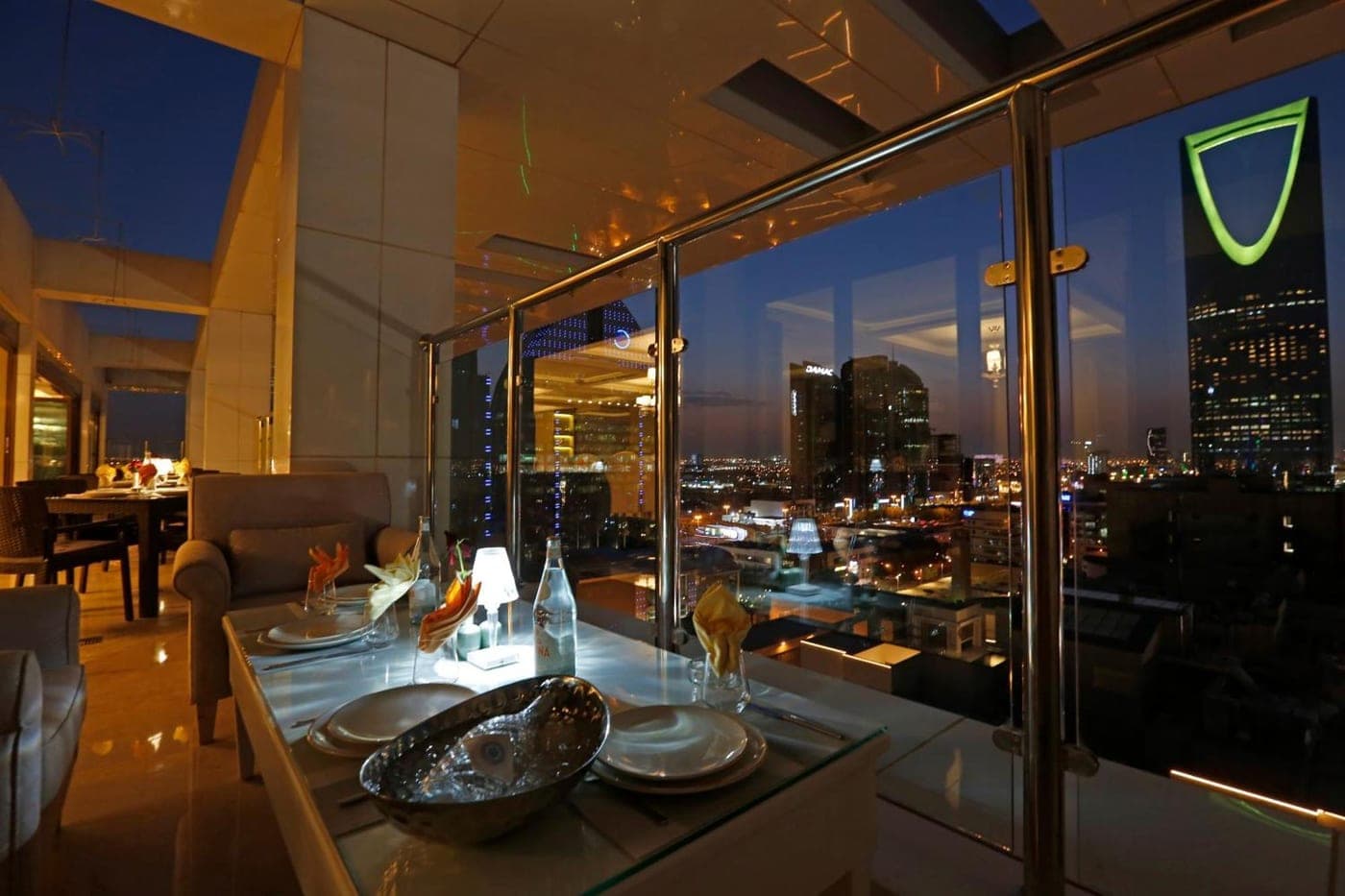 A private table set for dinner above the Riyadh skyline at night